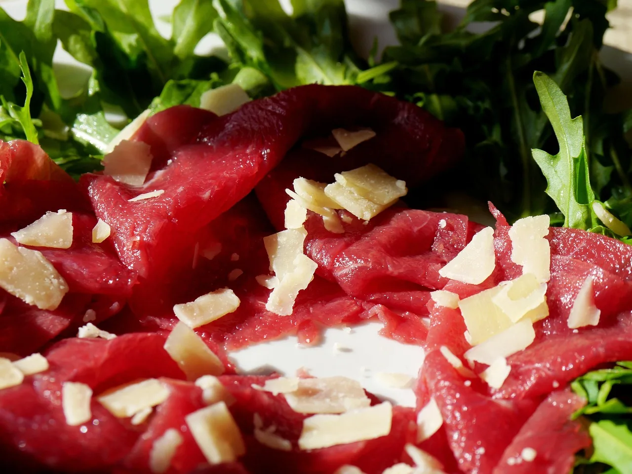 Bresaola su un piatto con un avviso di allerta per alcune categorie di consumatori.
