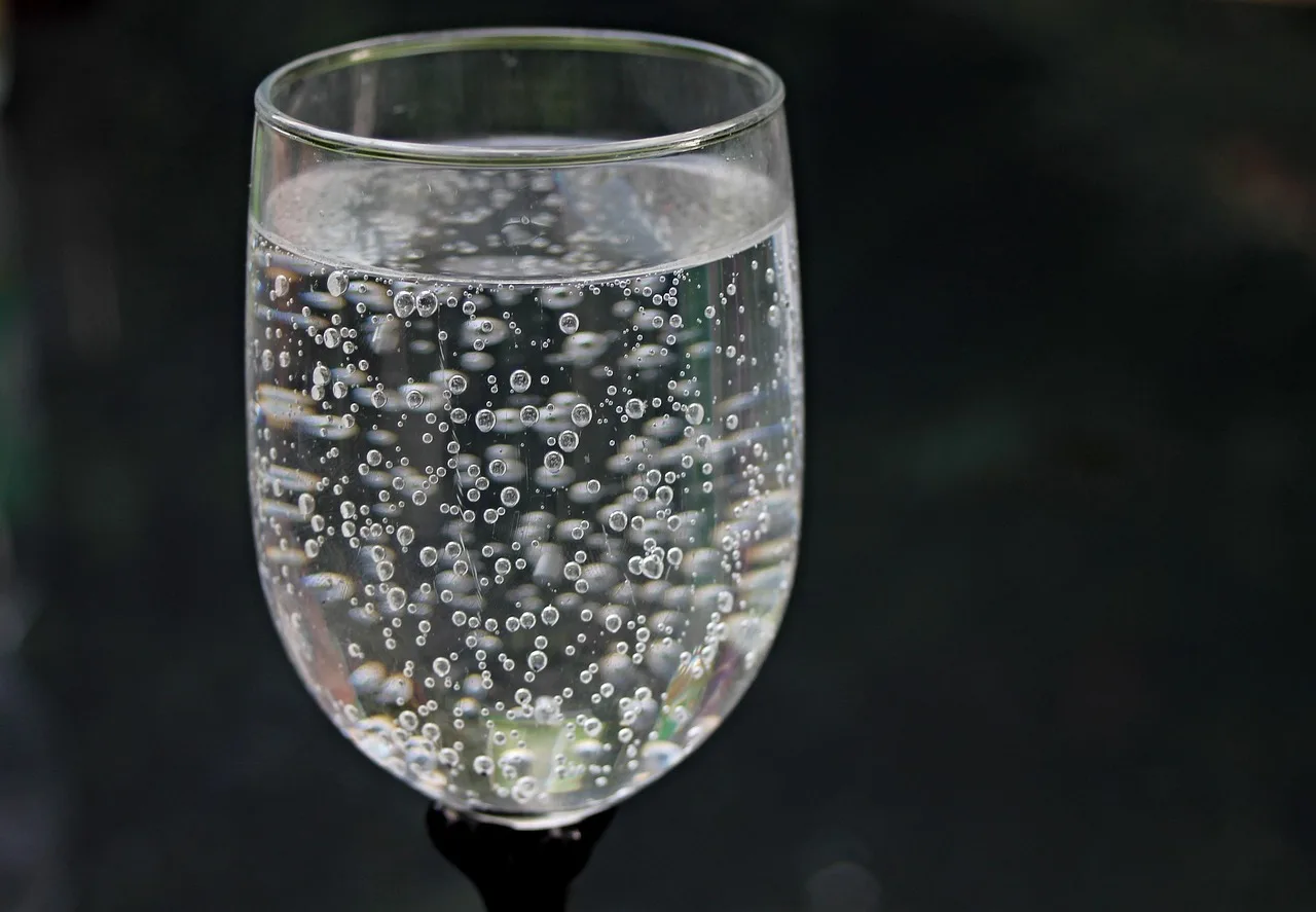 Bottiglia di acqua frizzante su un tavolo, simbolo di discussione su effetti sul peso.